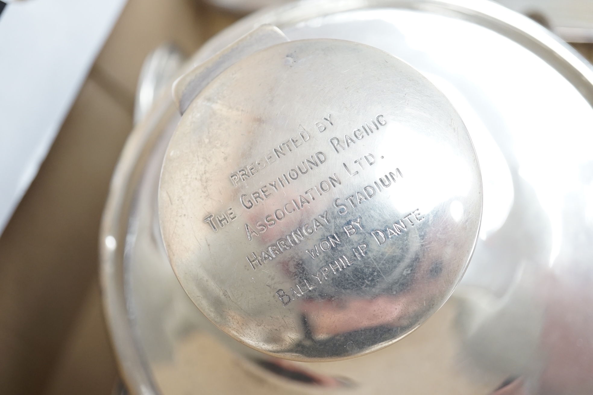 An Elizabeth II silver christening mug, three silver mounted dressing table items, a silver mounted desk calendar, a silver capstan inkwell and a sterling condiment. Condition - fair to good